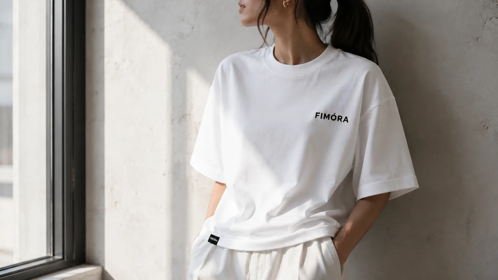 Female model wearing FIMÓRA white T-shirt by window light
